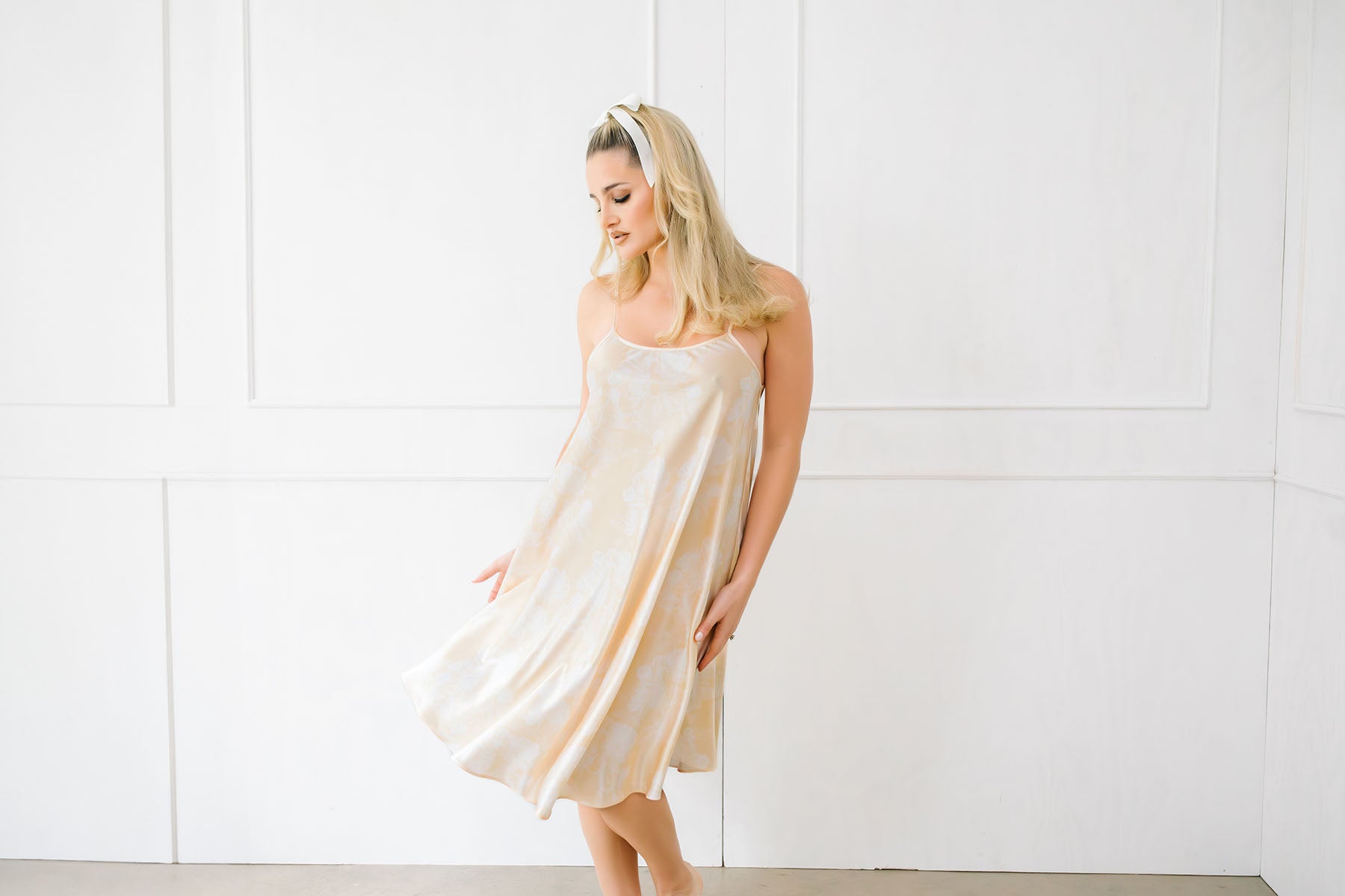 Woman wearing a light-colored dress against a white background
