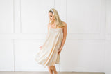 Woman wearing a light-colored dress against a white background